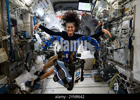 Stazione spaziale Internazionale, orbita terrestre. 15 novembre 2024. L'astronauta della NASA e il comandante della Expedition 72 Suni Williams colpisce una posa per imitare il free-flyer robotico Astrobee nel modulo di laboratorio Kibo della stazione spaziale Internazionale, 15 novembre 2024 in Earth Orbit. L'Astrobee ha bracci simili a tentacoli contenenti tamponi adesivi simili a geco per dimostrare le tecniche di cattura satellitare. Credito: Astronaut provided/NASA/Alamy Live News Foto Stock