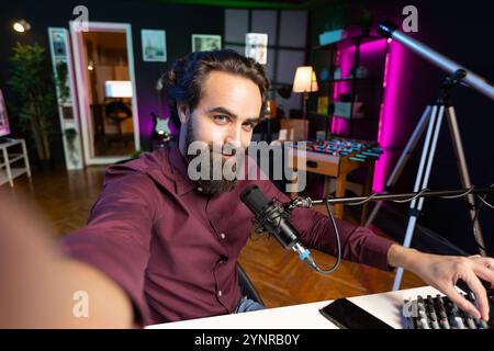 Artista ASMR che utilizza un microfono di qualità e una fotocamera per selfie in studio per realizzare video anti-stress, sussurrando suoni formicolosi. POV di un uomo che usa il microfono professionale per dormire indurre audio per la meditazione zen Foto Stock