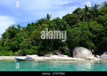 Isole Indonesia Anambas - Dinkor Island con barca da pesca e grandi rocce Foto Stock