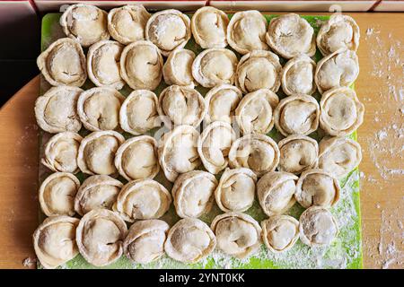 Gnocchi fatti a mano impilati in file su un vassoio Foto Stock