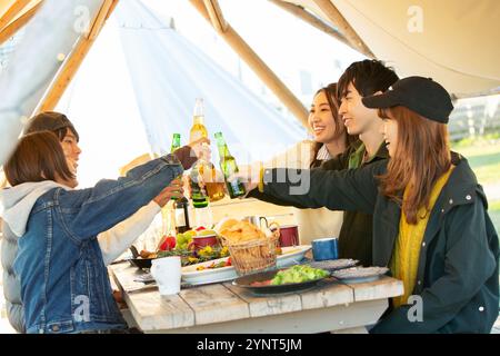 Uomo e donna sui vent'anni che fanno un brindisi sul cibo Foto Stock