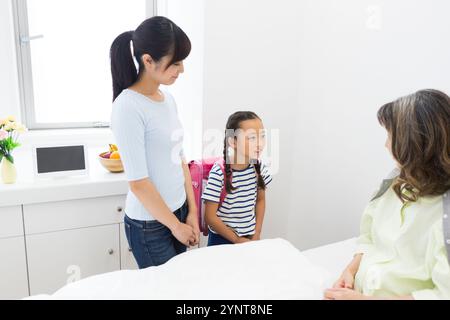 Donna anziana con membri della famiglia che sono venuti a trovarla Foto Stock