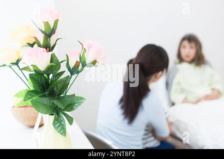 Donna anziana con membri della famiglia che sono venuti a trovarla Foto Stock