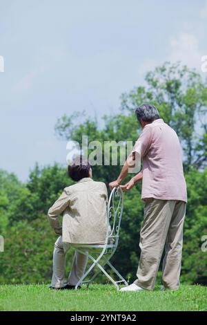 Giovane seduto su una sedia Foto Stock