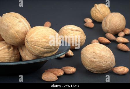 Primo piano di noci e mandorle fresche su sfondo nero Foto Stock