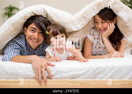 Famiglia nascosta sotto il piumone Foto Stock