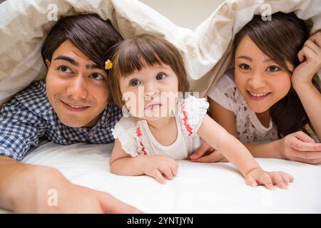 Famiglia nascosta sotto il piumone Foto Stock