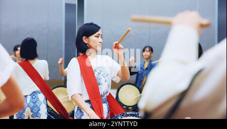 Giapponese, di apprendimento e donna con batteria per musica su strumento per performance, pratica e classe. Taiko, gente o batterista femminile in band per suonare Foto Stock