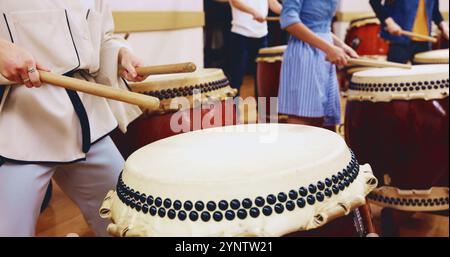 Giapponese, batteria e mani di persone in esibizione per musica su strumenti per la pratica del palco o la creatività. Taiko, impara canzone e batteristi in band Foto Stock