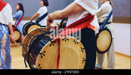 Giapponese, batteria e mani di persone nella tradizione per musica su strumenti per performance, creatività o classe. Taiko, arte o batteristi che imparano in band Foto Stock