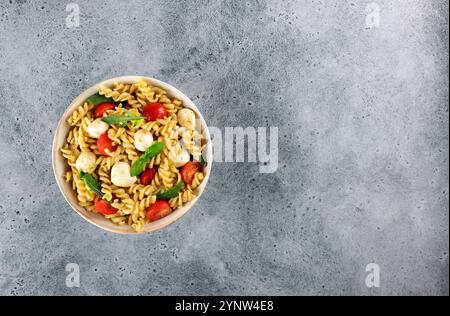 Insalata fredda italiana con fusilli, pomodori ciliegini, mozzarella, rucola. Vista dall'alto. Copia spazio. Foto Stock
