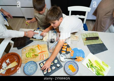 Contenuti UGC di una famiglia caucasica con due bambini che cucinano sushi a casa Foto Stock