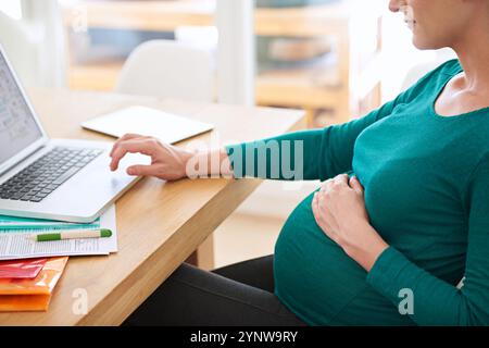 Donna incinta, mani o navigazione online con notebook per ricerche, informazioni o programmi a casa. Donna, libera professionista o gravidanza con Foto Stock
