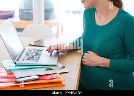 Donna incinta, mani o ricerca con notebook per navigare online, informazioni o comunicazioni a casa. Donna, libera professionista o gravidanza con Foto Stock