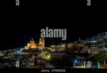 Illuminata di notte, la città di Taxco de Alarcon svela la sua splendida architettura storica e le strade animate. Le vivaci luci del buildi Foto Stock