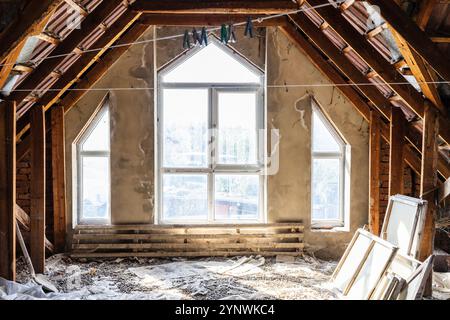 ha installato finestre in plastica e rimosso vecchie cornici in vetro e legno nell'attico della casa del villaggio Foto Stock
