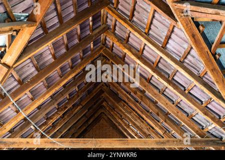 vista interna delle travi in legno che sostengono le tegole del tetto nell'attico della casa di campagna Foto Stock