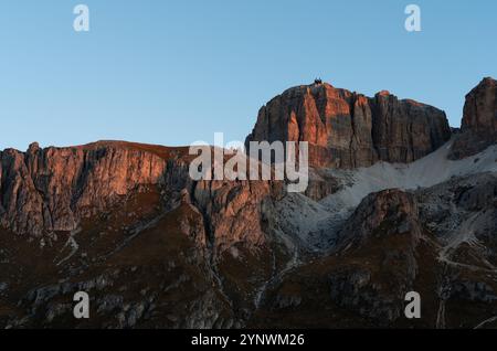 Cielo blu e alpenglow sulle scogliere sopra il passo Pordoi Foto Stock