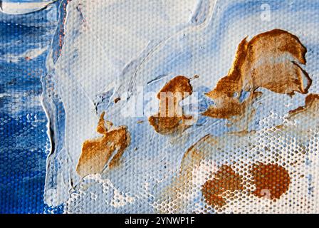 Strati di vernice acrilica blu, dorata e bianca su tela, per creare un design astratto dalla texture vivace. Foto Stock