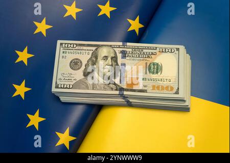 Aiuto finanziario all'Ucraina. Assistenza finanziaria, donazione, investimenti denaro su sfondo bandiera Ucraina. Dollari sulle bandiere ucraine ed europee. Foto Stock