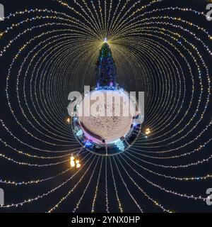 Anno nuovo piccolo pianeta con albero di Natale. Antenna sferica vista notturna panoramica a 360° sulla piazza festosa con illuminazione sotto forma di tenda Foto Stock
