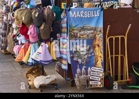 Marsiglia. Francia - 27 novembre 2024: Un vivace mercato di strada a Marsiglia, in Francia, che espone cappelli, asciugamani e souvenir colorati. Turisti Foto Stock