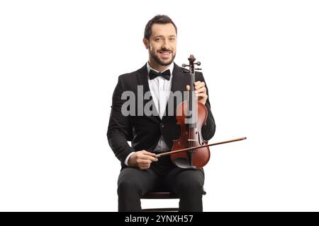 Giovane uomo elegante seduto e tenuto in mano un violino isolato su sfondo bianco Foto Stock