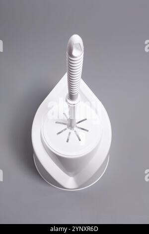 Mentre lo spazzolino del water è su sfondo grigio Foto Stock