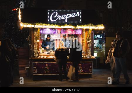 CITY SQUARE, LEEDS, REGNO UNITO - 25 NOVEMBRE 2024. Una colorata bancarella di mercatini che vende crepes agli acquirenti al mercato di Natale di Leeds in City Square, Leeds, Foto Stock