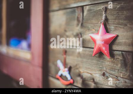 Primo piano di un cavallo a dondolo e ornamenti natalizi a forma di stella appesi su una stalla di legno in un mercatino di Natale, Innsbruck, Tirolo, Austria Foto Stock