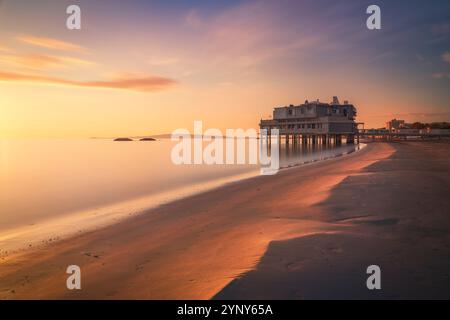 Spiaggia e litorale di Follonica con un edificio sul mare al tramonto. Fotografia a lunga esposizione. Provincia di Grosseto, regione Toscana, Italia Foto Stock