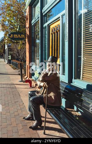Il giudice sul marciapiede dello scultore Seward Johnson siede su una panchina di fronte all'Hotel Jerome, cartello J-Bar sullo sfondo, Aspen, Colorado, USA. Foto Stock