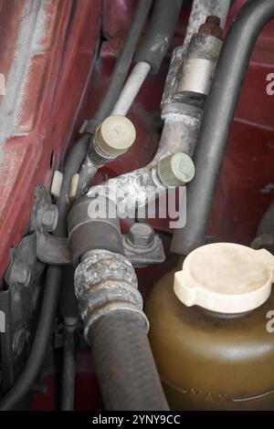 tubi ad alta e bassa pressione dell'impianto di climatizzazione nel motore dell'auto, tubi metallici trasportano il refrigerante in tutto il sistema, con un'attenzione selettiva Foto Stock