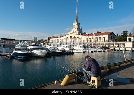 Linea di lancio dei pescatori in un porto turistico affollato con un'architettura affascinante e cieli azzurri cristallini - Sochi, Russia, 14 aprile 2023 Foto Stock