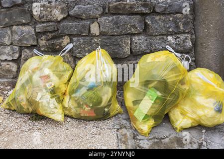 Primo piano di sacchetti di plastica gialli traslucidi riempiti con rifiuti domestici di vario tipo, Salona, Solin, Croazia, Europa Foto Stock