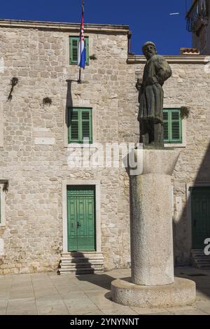 Statua della figura storica Giorgio da Sebenico / Juraj Dalmatinac di fronte a un vecchio edificio in pietra, Piazza della Cattedrale, Sibenico, Croazia, Europa Foto Stock