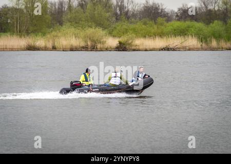 KAMPEN, PAESI BASSI, 30 MARZO 2024: Motoscafo con tre persone che sfrecciano sul fiume IJssel nei paesi bassi Foto Stock