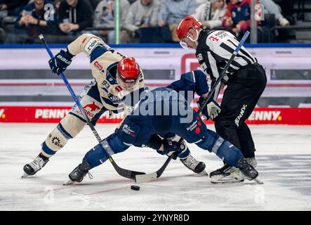 Linesperson Lukas Pfriem fuehrt ein bully / Faceoff aus zwischen Sebastian Uvira (Schwenninger Wild Wings, n. 93) e Patrick Hager (EHC Red Bull Muenchen, n. 52). GER, EHC Red Bull Muenchen vs. Schwenninger Wild Wings, Eishockey, DEL, 20. Spieltag, Saison 2024/2025, 26.11.2024. Foto: Eibner-Pressefoto/Heike Feiner Foto Stock