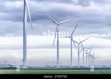 Fila di turbine eoliche al mattino presto in un paesaggio olandese pianeggiante Foto Stock