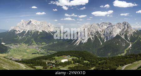 Montagne Zugspitze e Sonnenspitze. Città Ehrwald nella valle. Preso dalla funivia di Grubig Foto Stock