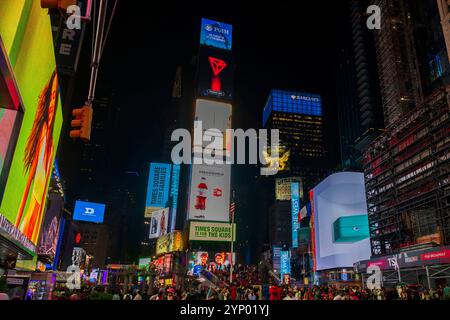 Vista notturna di Times Square a New York City piena di cartelloni luminosi, pubblicità e folla di turisti sotto il cielo notturno. New York. STATI UNITI. Foto Stock