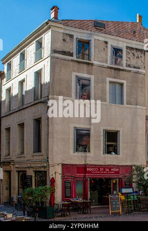 Piccoli caffè ed edifici di fronte alla chiesa Eglise Saint-Roch de Montpellier a Montpellier, Francia Foto Stock