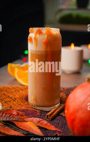 Pumpkin Spice latte su sfondo nero in legno, spazio copia. Bevanda autunnale di stagione con spezie e zucche biologiche Foto Stock