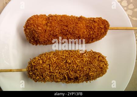 Hot Cheetos e Ramen Corn Dog su un piatto Foto Stock