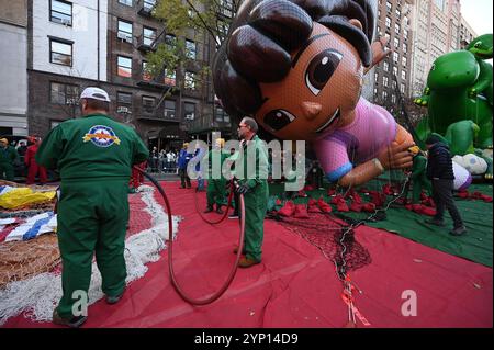 New York, Stati Uniti. 27 novembre 2024. Dora il pallone Explorer si tiene sotto una rete durante l'inflazione annuale dei palloni alla vigilia della Macy's Thanksgiving Day Parade del 2024, New York, NY, 27 novembre 2024. Migliaia di newyorkesi e turisti hanno la possibilità di guardare più di 30 palloncini mentre si gonfiavano e si preparavano per la 98a edizione della Parata il 28 novembre. (Foto di Anthony Behar/Sipa USA) credito: SIPA USA/Alamy Live News Foto Stock