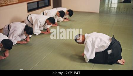 Inchino, onore e persone in studio di arti marziali per lezioni di pratica, allenamento o autodifesa. Cultura, karate e gruppo di studenti con rispetto o. Foto Stock