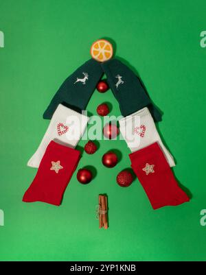 Albero di Natale fatto di calze colorate con palle di Natale rosse Foto Stock