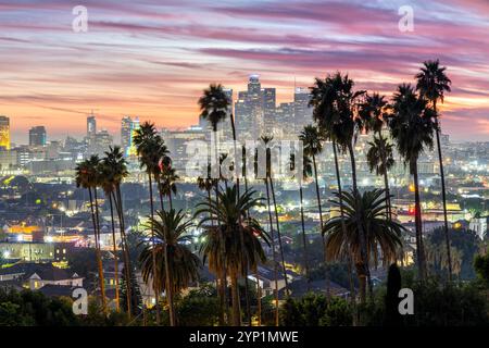 Skyline di Los Angeles e centro città con palme al tramonto a Ela Park, California, Stati Uniti Foto Stock