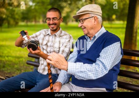 Ritratto di nonno felice e nipote nel parco. Stanno trascorrendo del tempo insieme e si divertono. Foto Stock