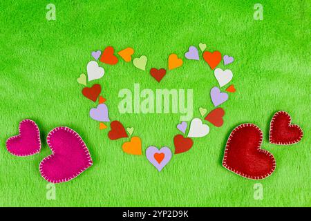 cuori di carta colorati a forma di cuore un panno verde Foto Stock